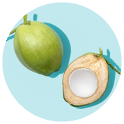 A vibrant image displaying a whole green coconut alongside a cut half with white flesh visible, set against a light blue circular background.