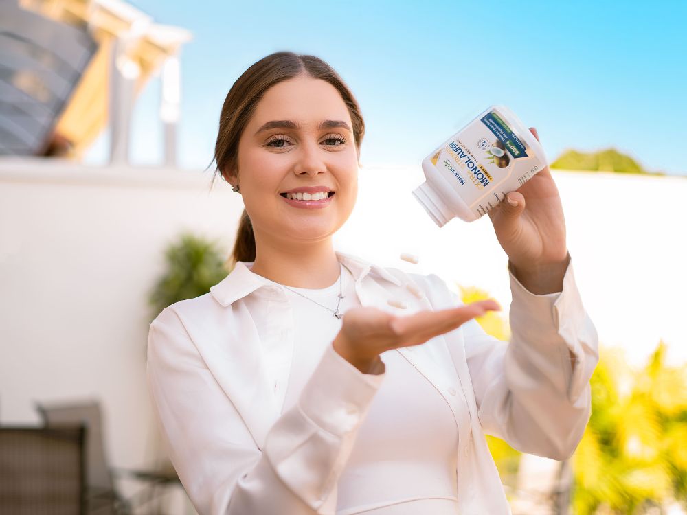 Woman pouring Extra Strength Monolaurin capsule outdoor