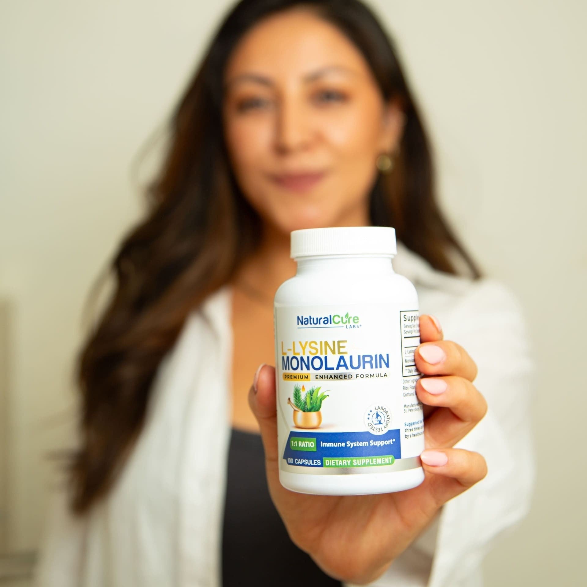 Woman resting head on hand holding L-Lysine with Monolaurin bottle